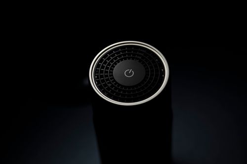 Free High angle of round wireless smart speaker with power button placed on table Stock Photo