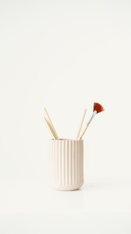 Close-up of a Cup with Paintbrushes on White Background 