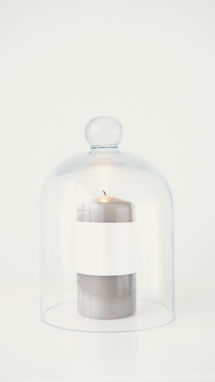 A Glass Cloches Over A Candle