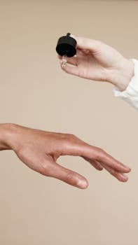 Two hands applying skin care oil with a dropper. Ideal for wellness and beauty themes.