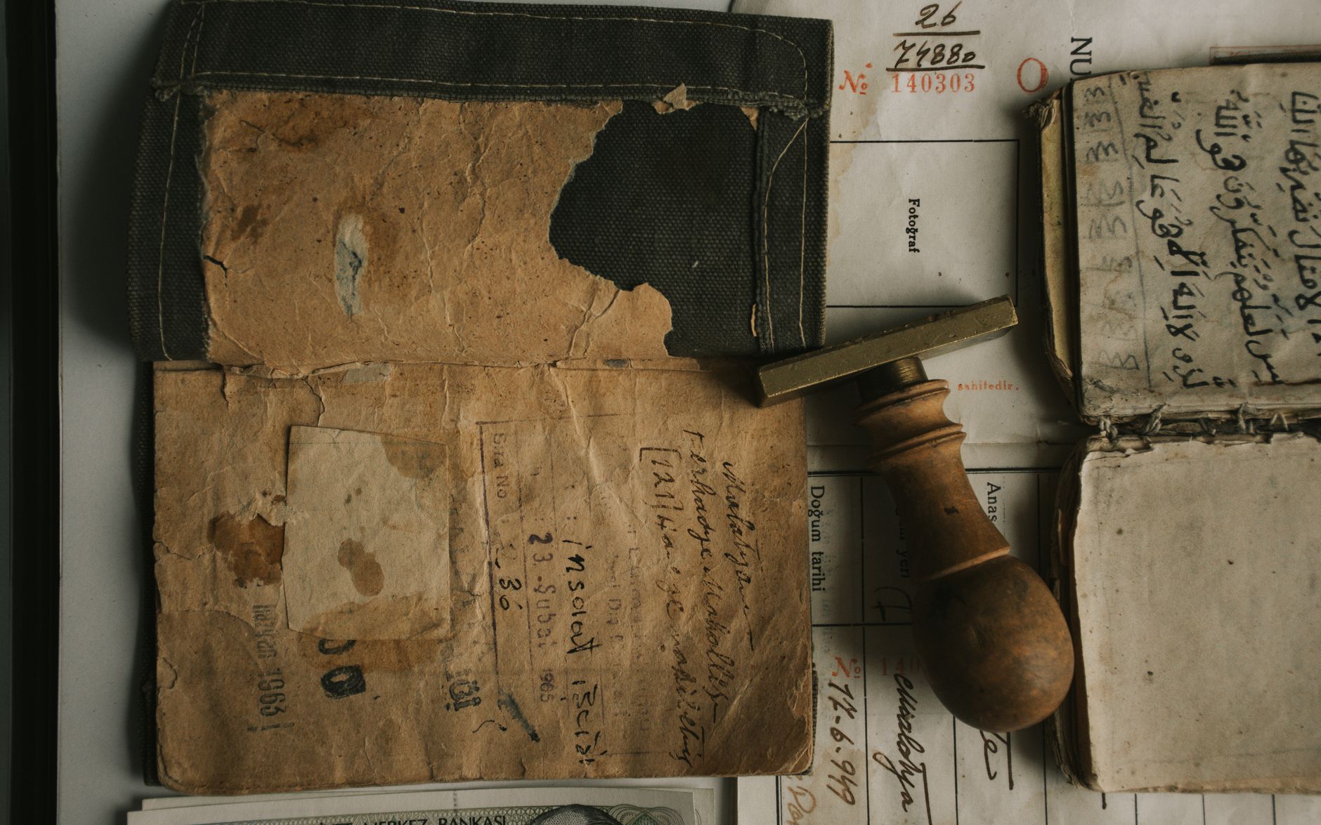 Top view of vintage documents and a wooden stamp, showcasing historical writing and paper textures.