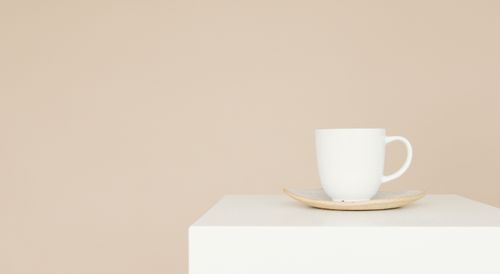 Free Elegant white coffee cup and saucer on a neutral background, perfect for branding or advertising. Stock Photo