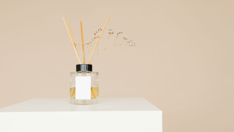 A minimal diffuser bottle on a plain pedestal