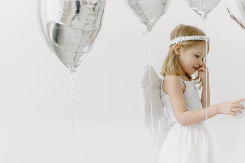 Girl Wearing a Costume Standing Beside Balloons