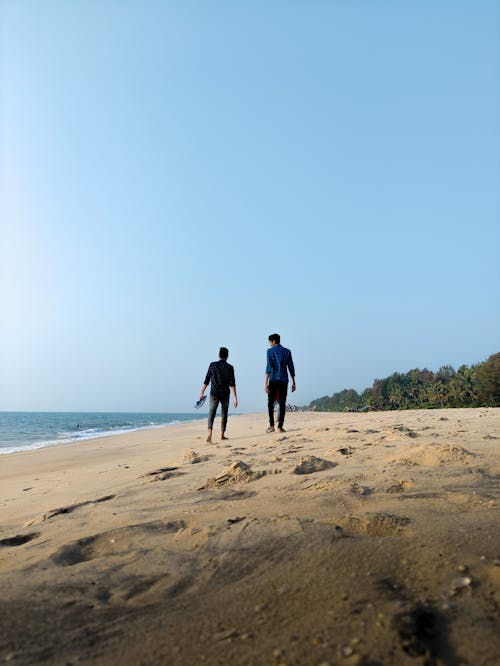 Back View of Men Walking on the Beach 