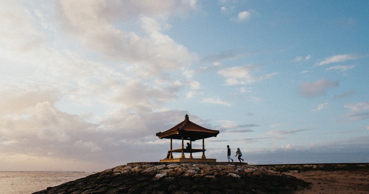 Traditional Balinese gazebo on a stone breakwater at Sanur beach at sunrise, the coastal zone with Bali's most confirmed infrastructure in 2026