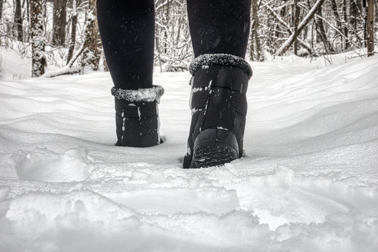 Close-up Of Person In Winter Boots Walking In Snow