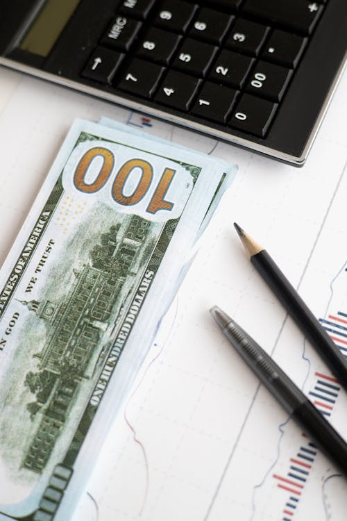 Bank Notes beside Black Calculator