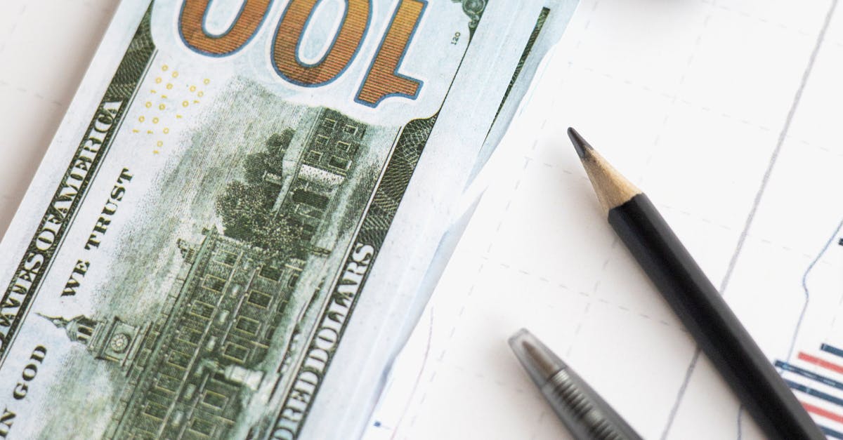 Photo by Hanna Pad Stack of hundred dollar bills beside calculator and graph for financial analysis