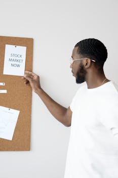 Businessman in white analyzing stock market insights on a corkboard.