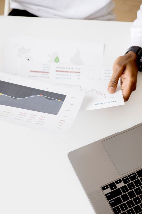 Profissional avaliando relatórios de desempenho e projeções antes de investir
