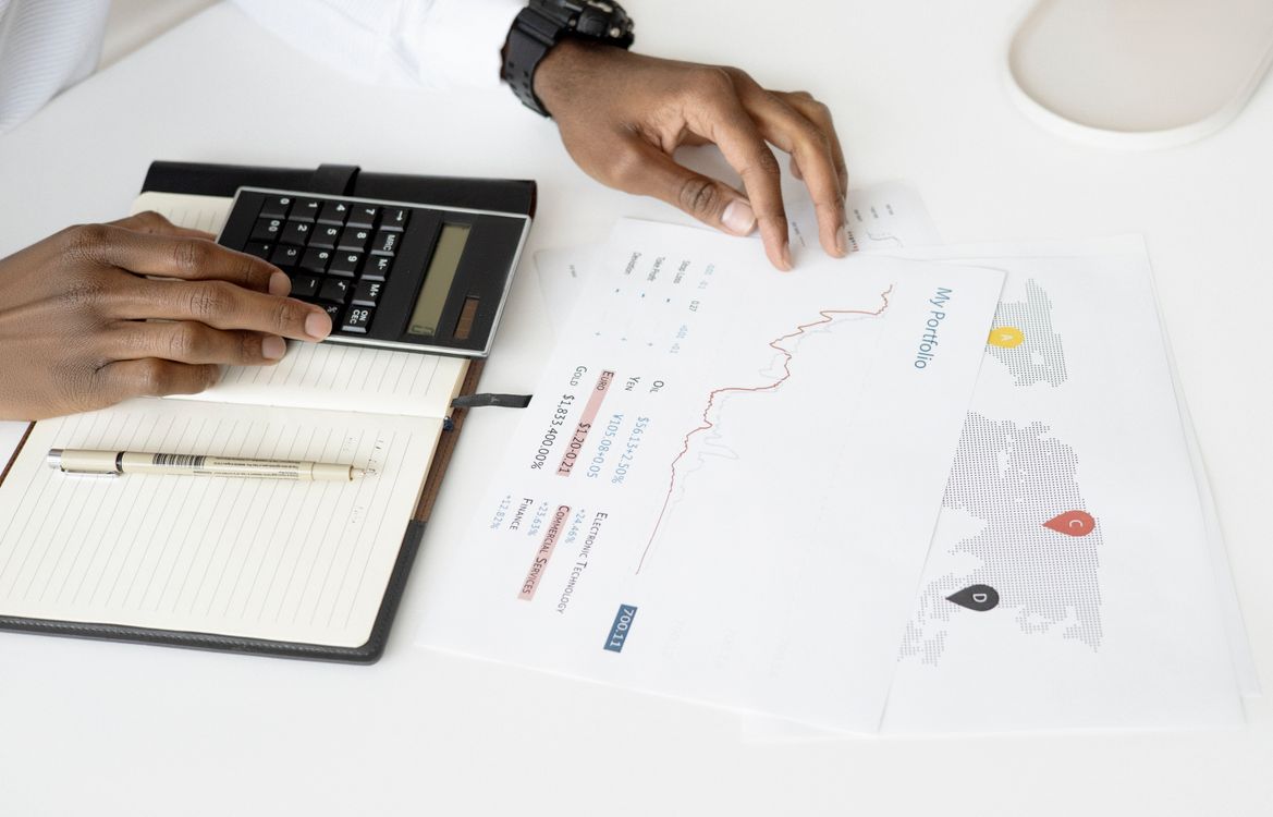 Profissional analisando projeções financeiras com calculadora e relatórios