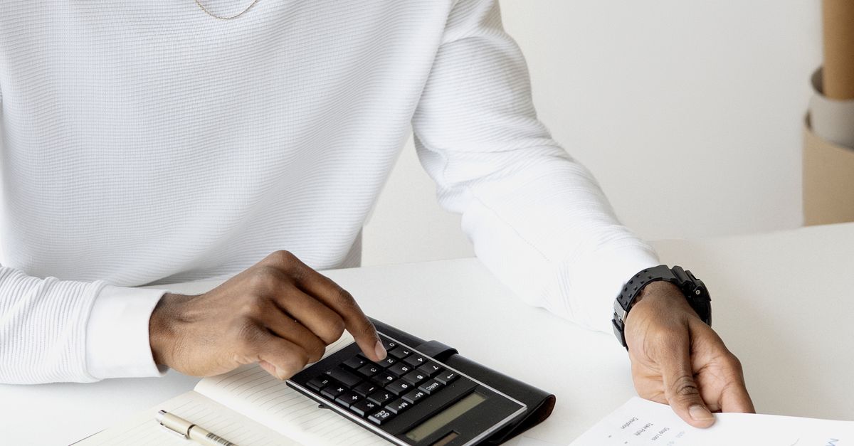 Person comparing documents and costs with a calculator