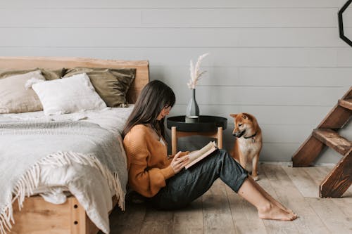 A Woman Sitting on the Floor Reading a Book