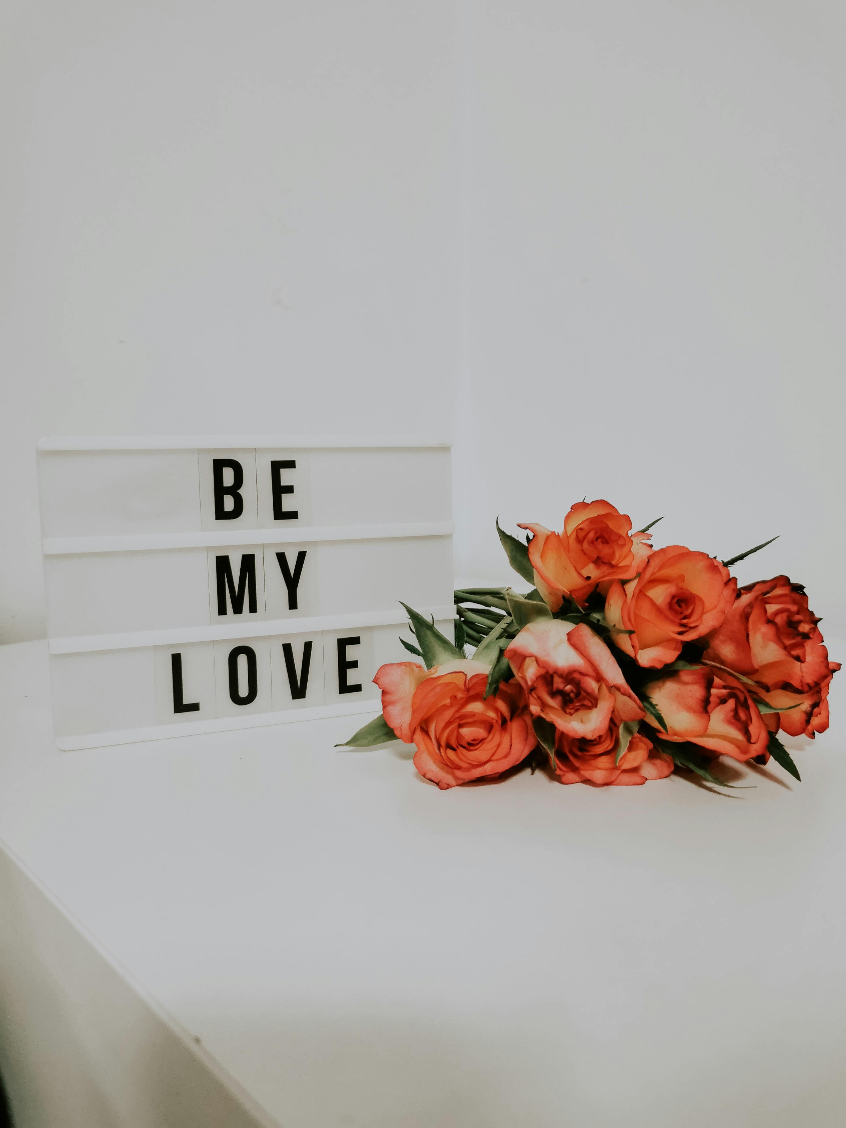 red roses on white table beside a marquee sign