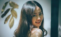 在优雅的工作室环境中，一位长发美丽、微笑温暖的亚洲女性肖像被拍摄下来