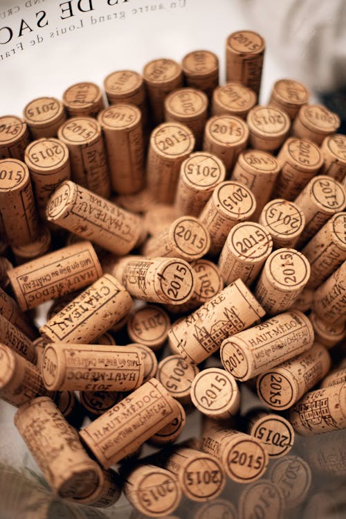 From above of pile of similar bottle cork stoppers of alcohol drinks stacked on table