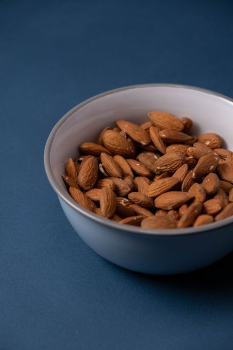 Almonds in a bowl on a blue background