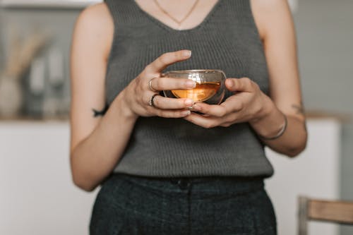 Free A Woman in Gray Tank Top Holding a Cup of Tea Stock Photo