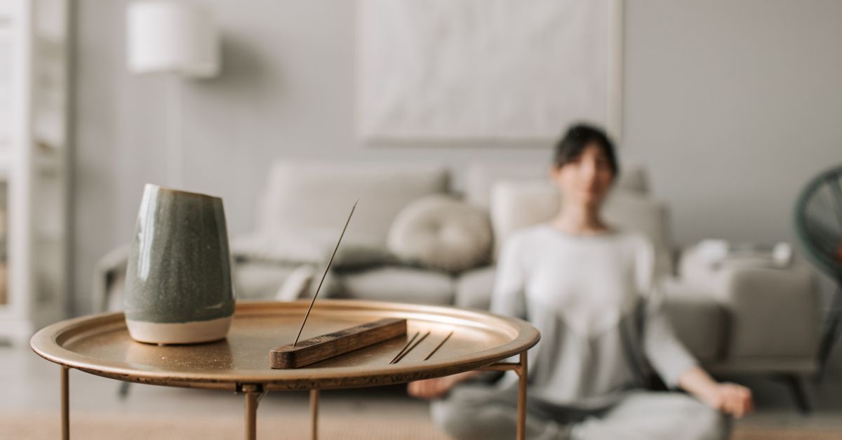 Person meditating in a minimalist living room with natural light