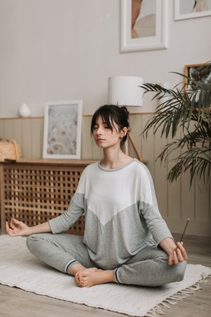 A woman sitting quietly at home during a guided practice. Photo by Vlada Karpovich on Pexels.