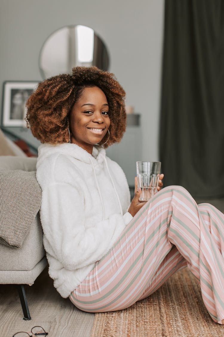 A Woman Holding A Glass Of Water 