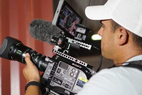 Free Videographer with a professional camera capturing footage, focused on the monitor display. Stock Photo