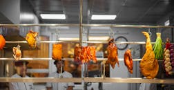 室内环境中悬挂着肉类和蔬菜的充满活力的市场场景