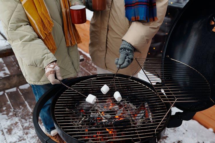 People Roasting Marshmallows Over The Fire