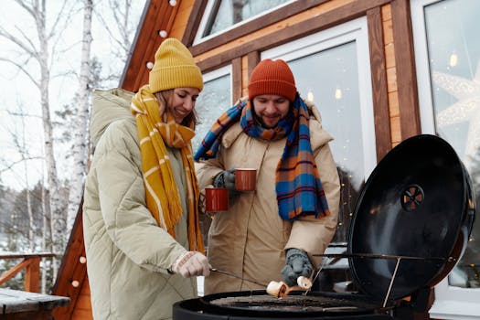 Couple enjoys winter barbecue while wearing cozy jackets and scarfs.