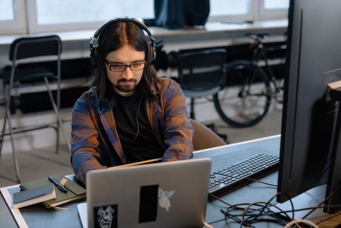 Developer coding on a laptop in a studio office — photo by cottonbro studio on Pexels