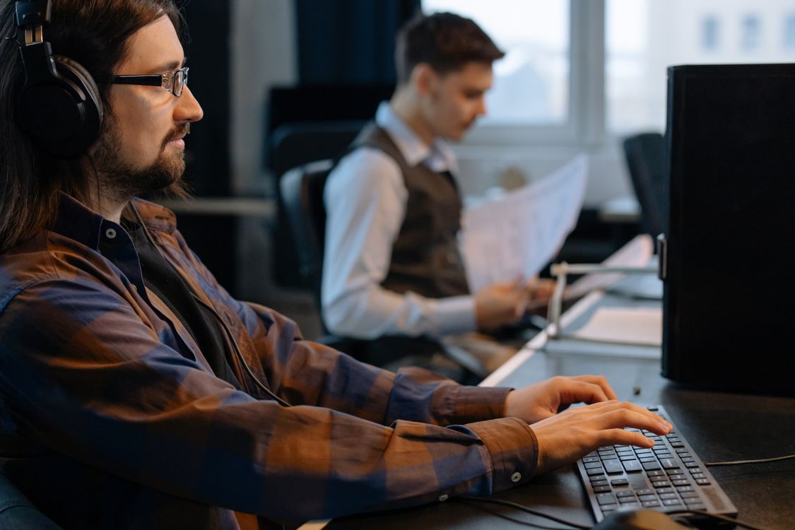 Men Sitting at the Desks in an Office and Using Computers · Free Stock ...