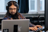 Man Sitting at the Desk in an Office and Using Computers