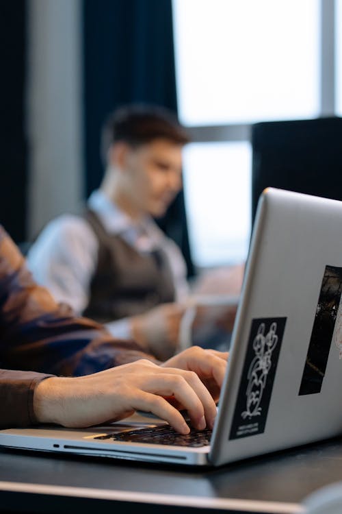 Close-up of Office Workers Sitting at the Desks and Using Computers 