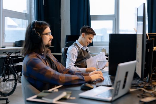 Two men collaborating in a modern office setting, focusing on teamwork and productivity.