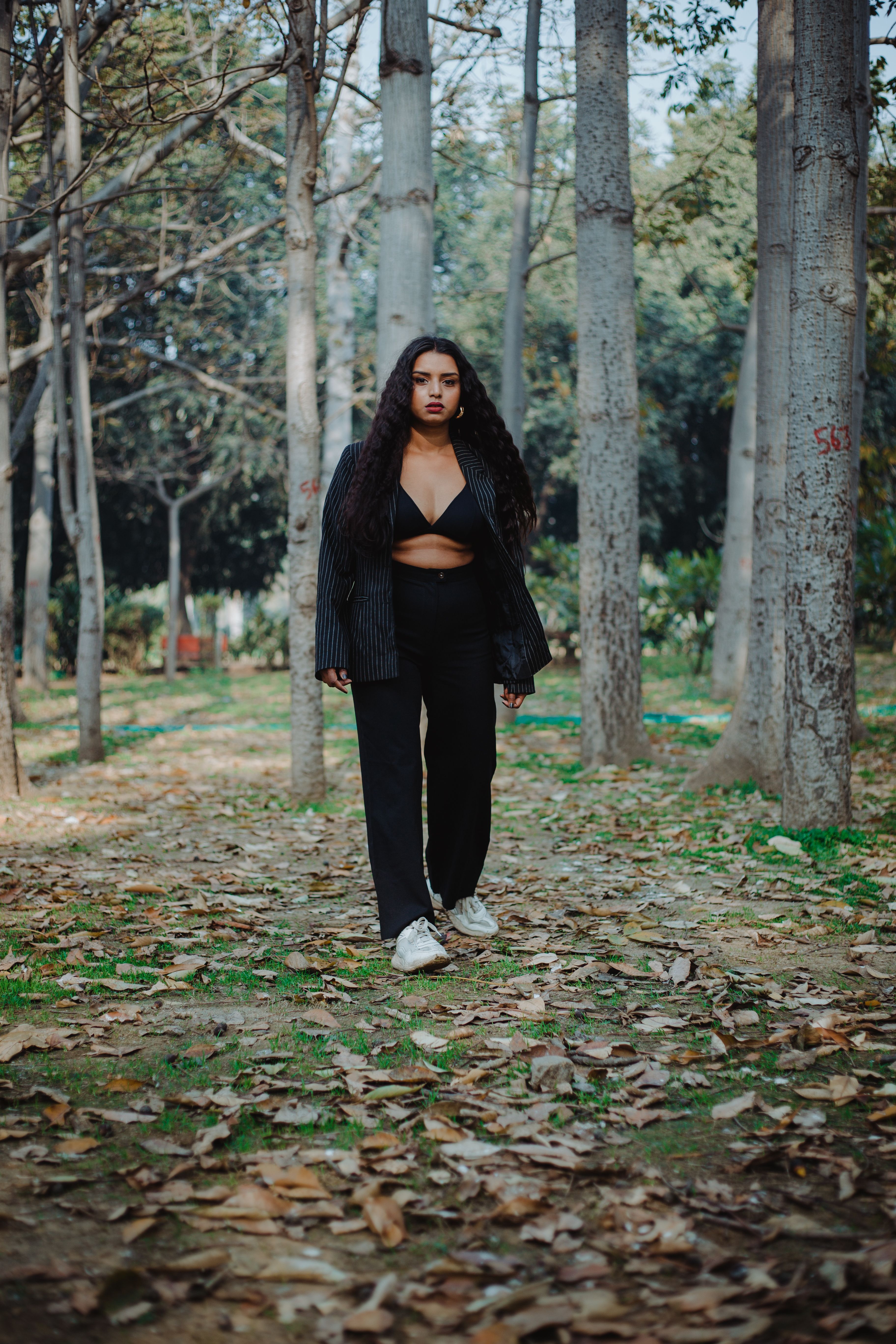 Stylish woman standing in autumn forest · Free Stock Photo