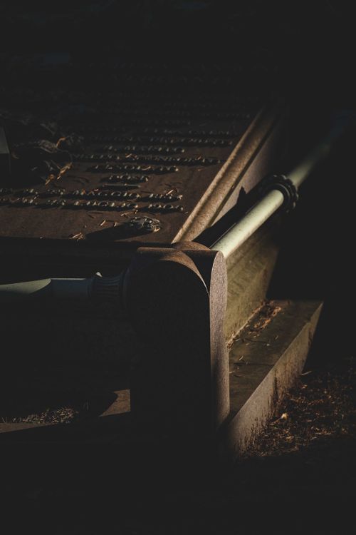 Free Carved epitaph in remembrance of dead on stone tombstone on grave at cemetery at night Stock Photo