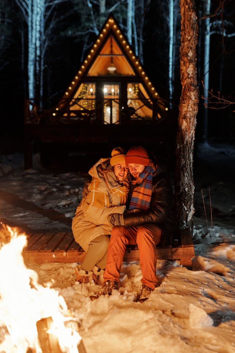 Couple Hugging By Bonfire In Winter