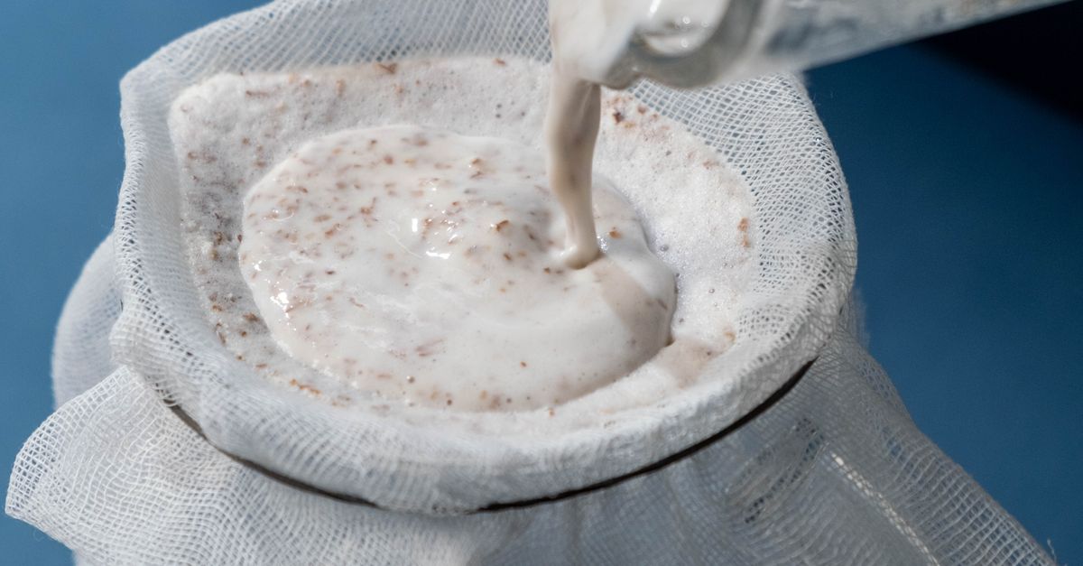 Close-up of White Liquid Being Strained into a Glass Jar · Free Stock Photo