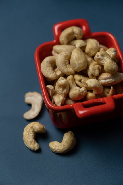 Close-up of organic cashews in a red bowl on a dark background, highlighting healthy snacking. - Understanding Nutritional Needs of Children and the Importance of Healthy Snacks