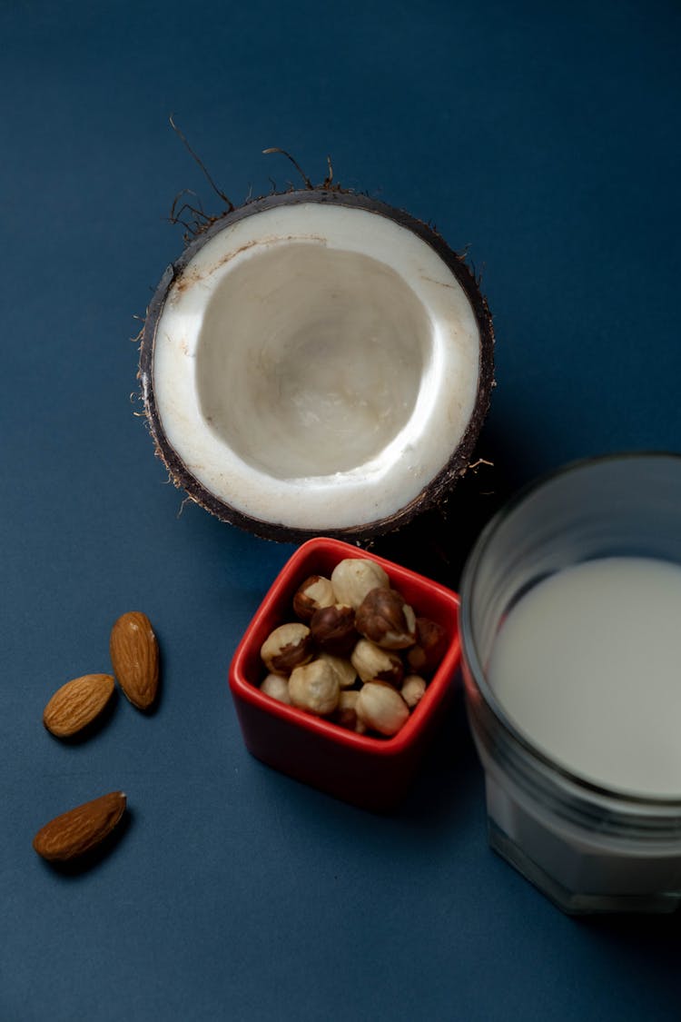 Raw Coconut Meat In Coconut Shell Beside Almond Nuts