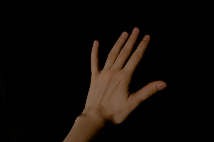 A Persons Left Hand On Black Background