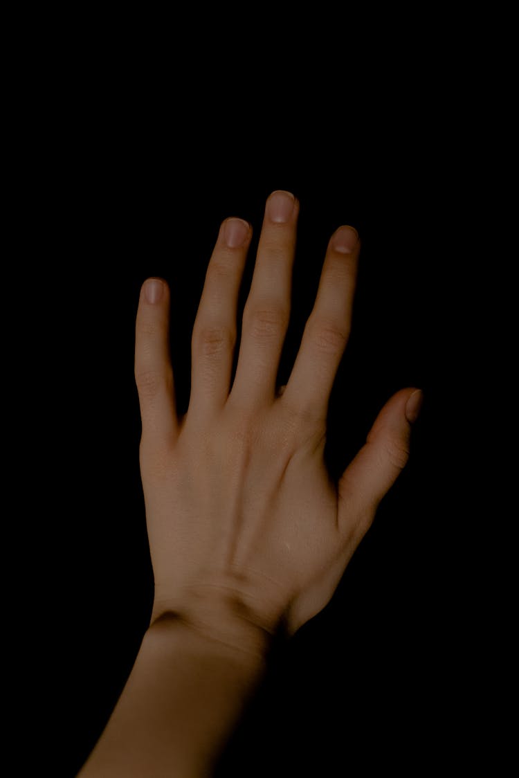 A Persons Left Hand On Black Background