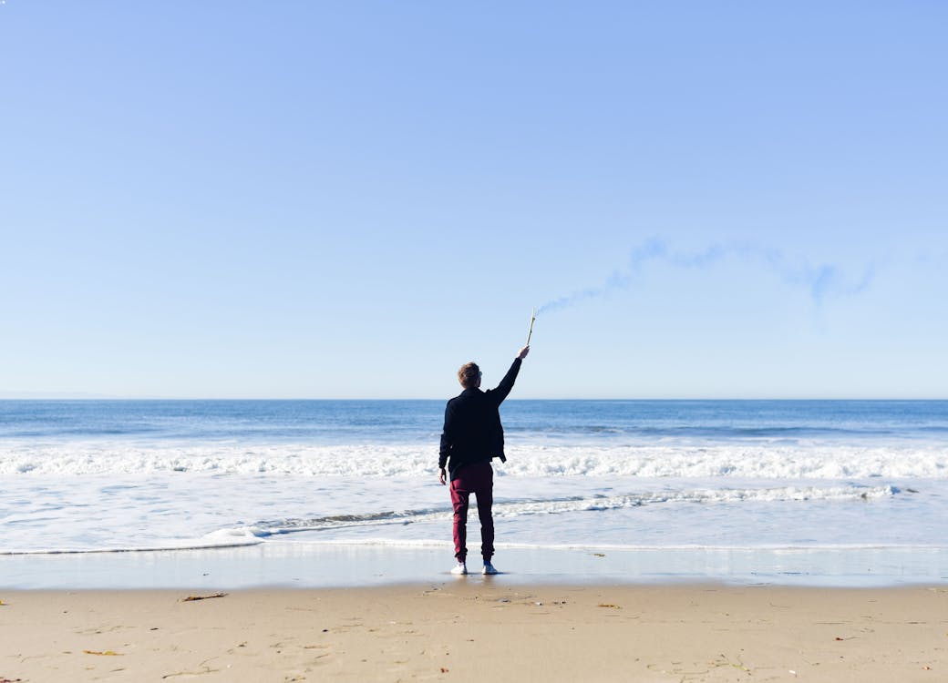 Free Person Standing on Seashore Stock Photo