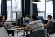 Men Sitting at the Desks in an Office and Using Computers