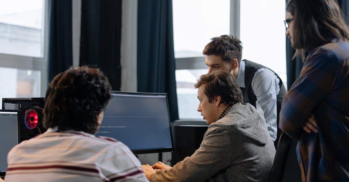 Group of developers working together on a computer programming project indoors.