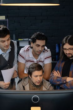 Group of young professionals collaborating on a project in a tech office setting.