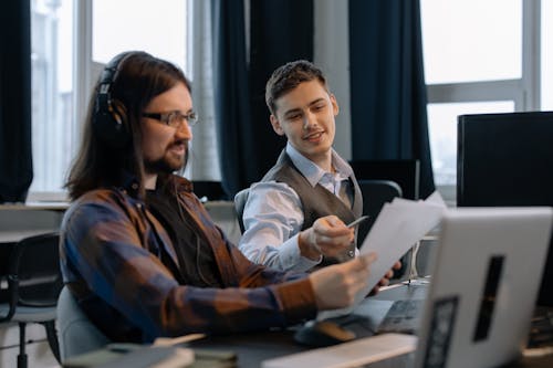 Men Sitting at the Desks in an Office and Using Computers 