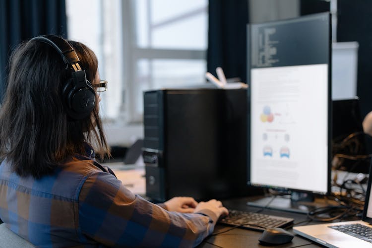 Employee In Headphones Working On A Computer