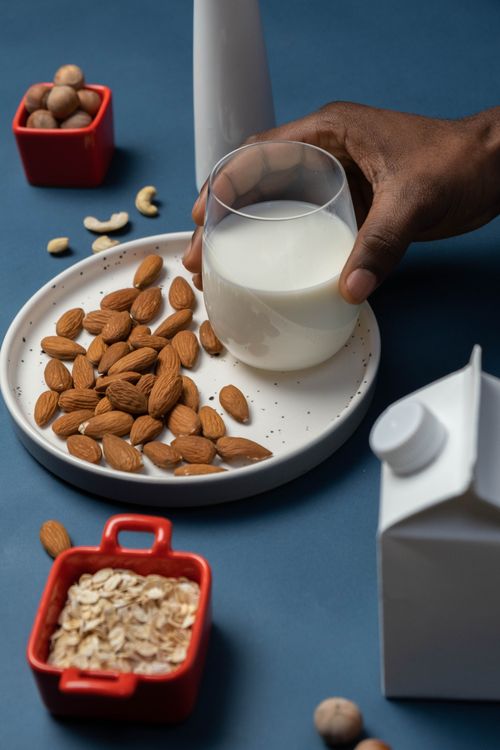 Free A nutritious setup with almonds, a glass of milk, oats, and nuts on a plate. Stock Photo
